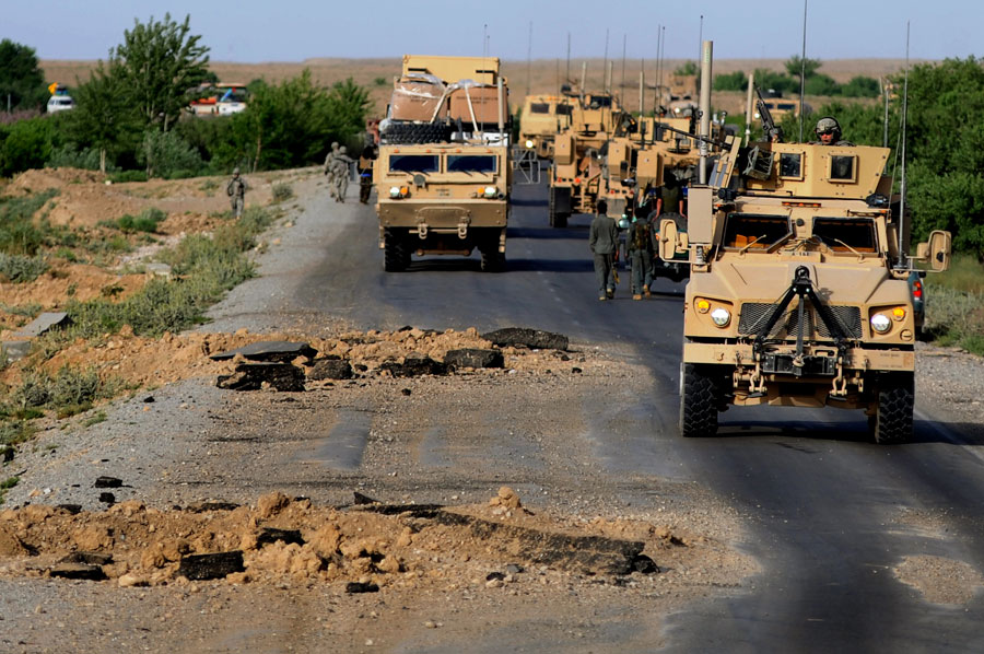 A convoy makes it's way around gigantic IED blast holes