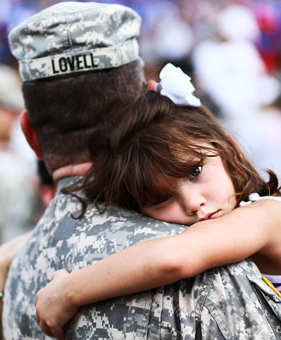 Five-year-old daughter hugs father during welcome home ceremony