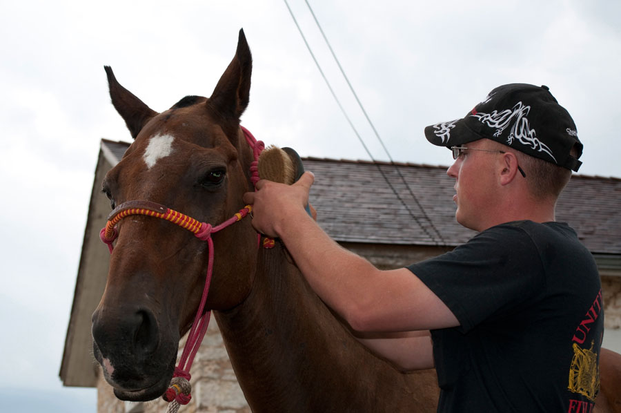 Soldier grooms retiring horse which will retire to Spirit Horse Chisholm Trail Therapy Center