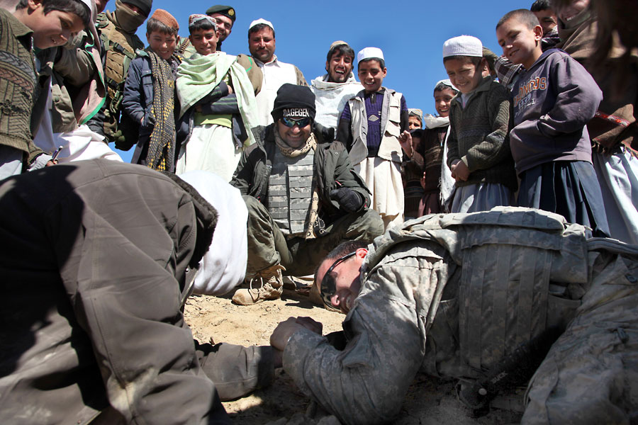 A Soldier takes a break to arm wrestle an Afghan man