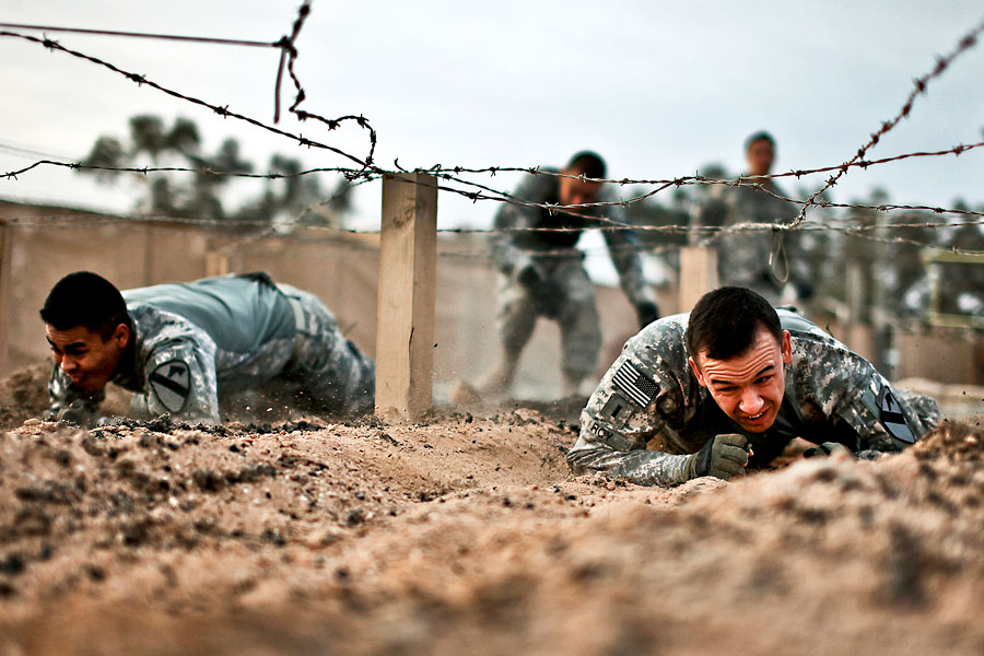 Soldiers crawl through an obstacle course at Camp Taji, Iraq