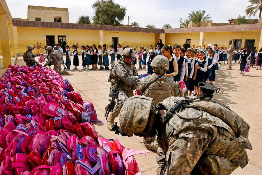 United States Soldiers hand out hundreds of backpacks at Iraqi girl's school filled with school supplies