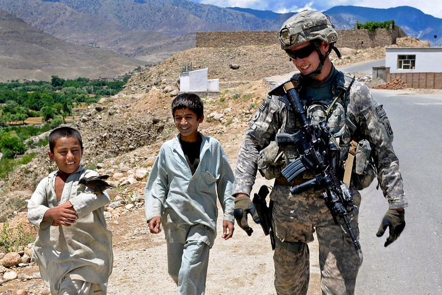 An Afghan youth attempts to sell a tame bird to Soldier