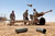 Soldiers stands ready to dispose of spent Howitzer brass during artillery training