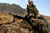 Soldiers peering through scope of rifle