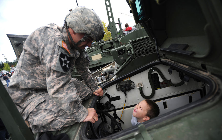 Soldier showing child Stryker combat vehicle