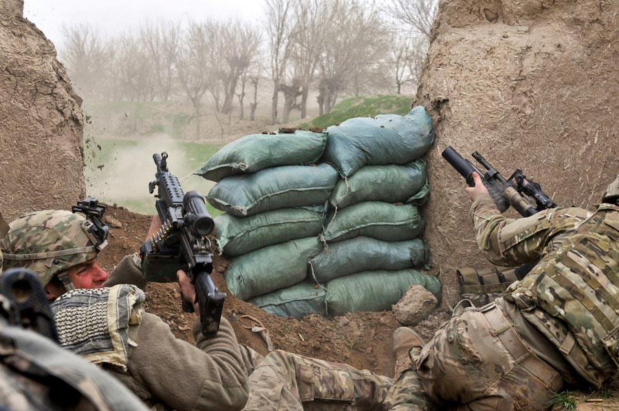 Private First Class Ben Bradley ducks away from small-arms fire, as fellow scout Sergeant Jeff Sheppard, launches grenade at enemy’s position during combat engagement