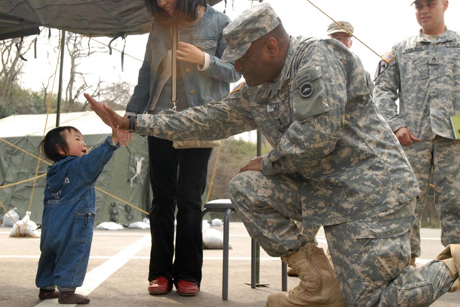 Major General Michael T. Harrison high fives a toddler displaced by the Great East Earthquake in Matsushima, Japan