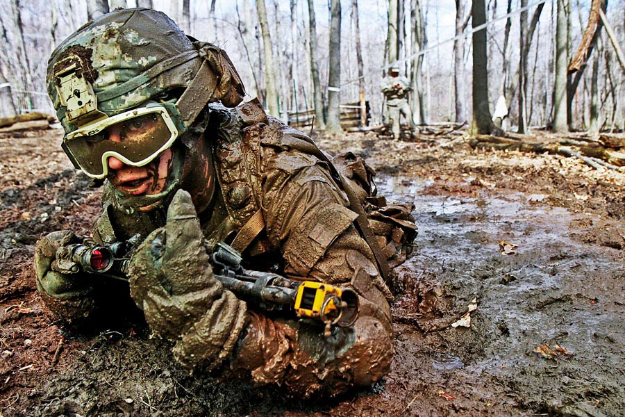 Crawling through mud, Private Charles Shidler searches for the next covered fighting position during individual movement techniques training