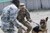 Specialist Marc Whittaker, a canine handler, restrains his military working dog