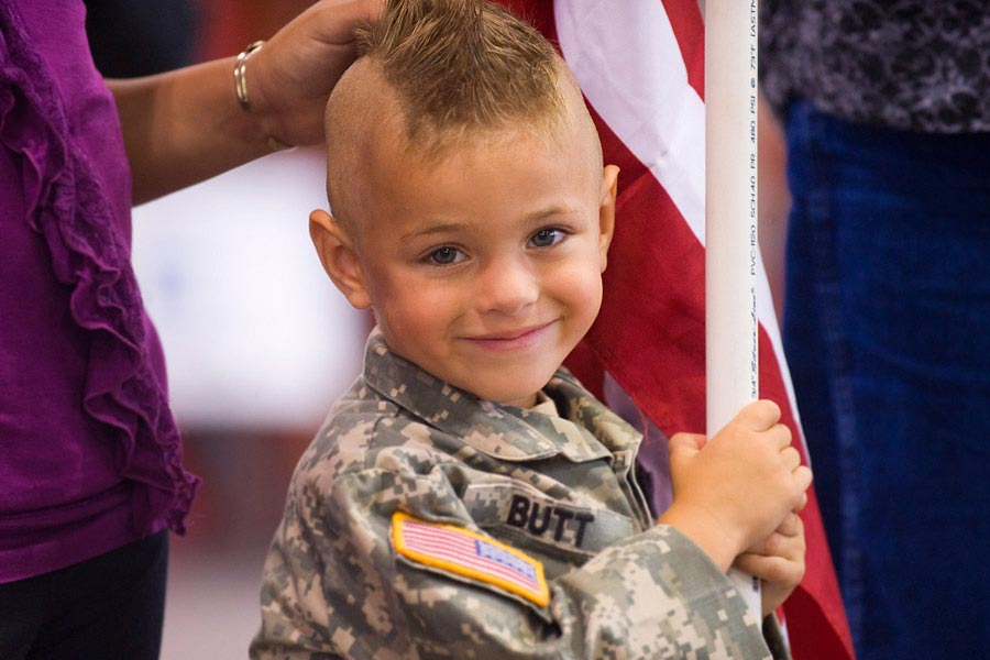 Gunner Butt, son of Sergeant First Class Walter Butt, stands with his family waiting for the return of their deployed Soldier