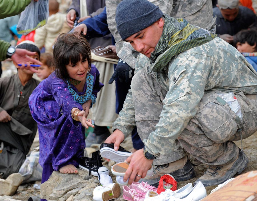 Sergeant First Class Manuel Delarosa finds shoes for a young Afghan girl
