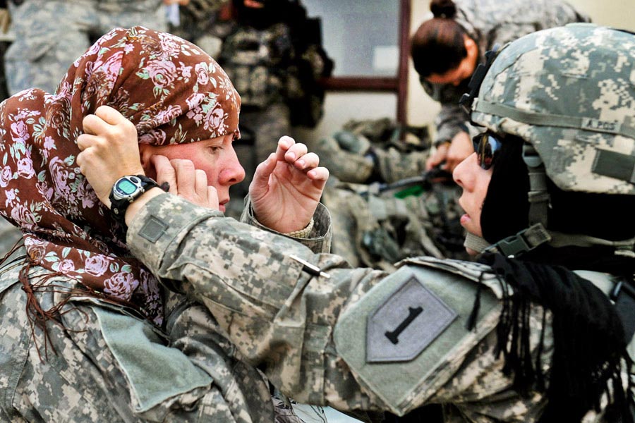Major Rosemary Reed helping Sergeant First Class Paula Reill with her head scarf