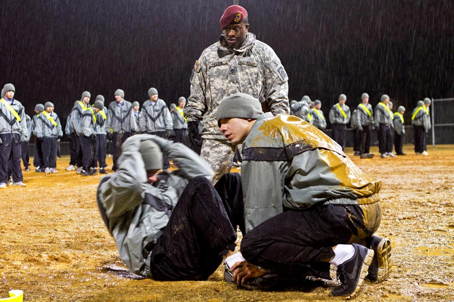 Sergeant First Class Eric Lloyd grades sit-up event of an Army Physical Fitness Test