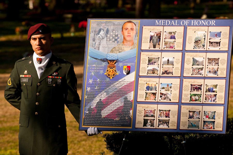 Soldier holds a poster depicting Staff Sergeant Robert Miller‘s life and Medal of Honor citation