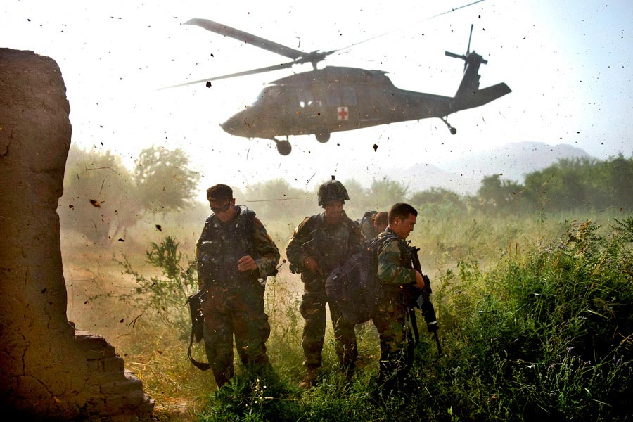 Afghan commandos, with the Afghan National Army’s 3rd Commando Kandak, shield their faces from flying debris after loading a wounded commando on a UH-60 Black Hawk helicopter