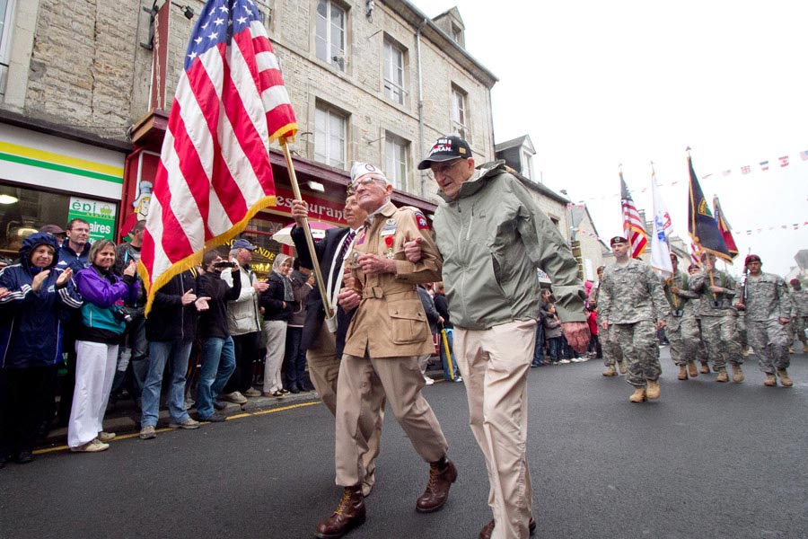 Zane Schlemmer, a veteran United States Army paratrooper who jumped into northern France as a sergeant with the 82nd Airborne Division, walks in his jump boots down the main street of Sainte-Mère-Église with other World War II veterans during the 67th anniversary of the Allied invasion of France