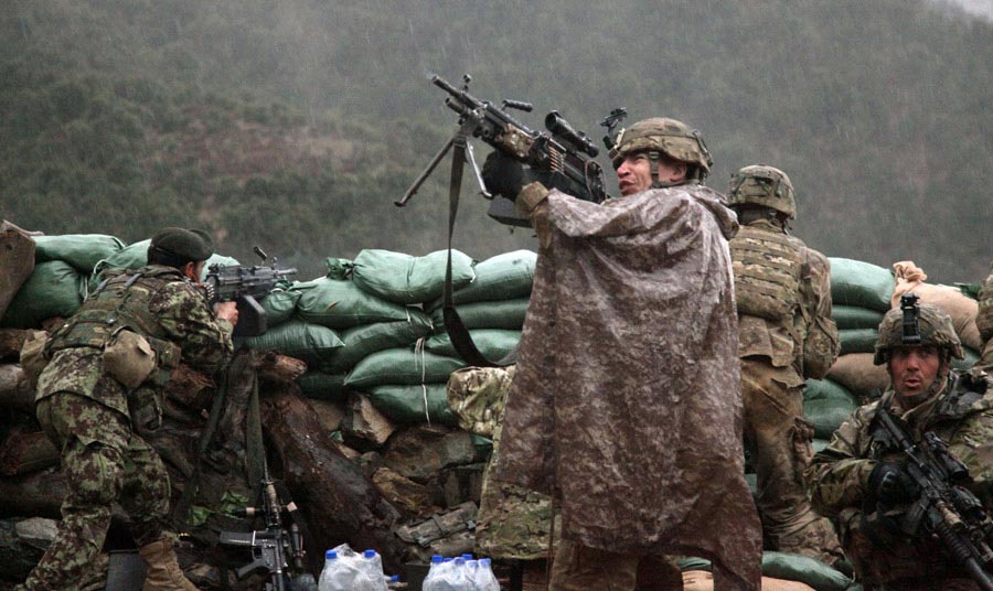 Soldier returns fire with a M249 light machine gun during combat operations in the valley of Barawala Kalet, Kunar province, Afghanistan