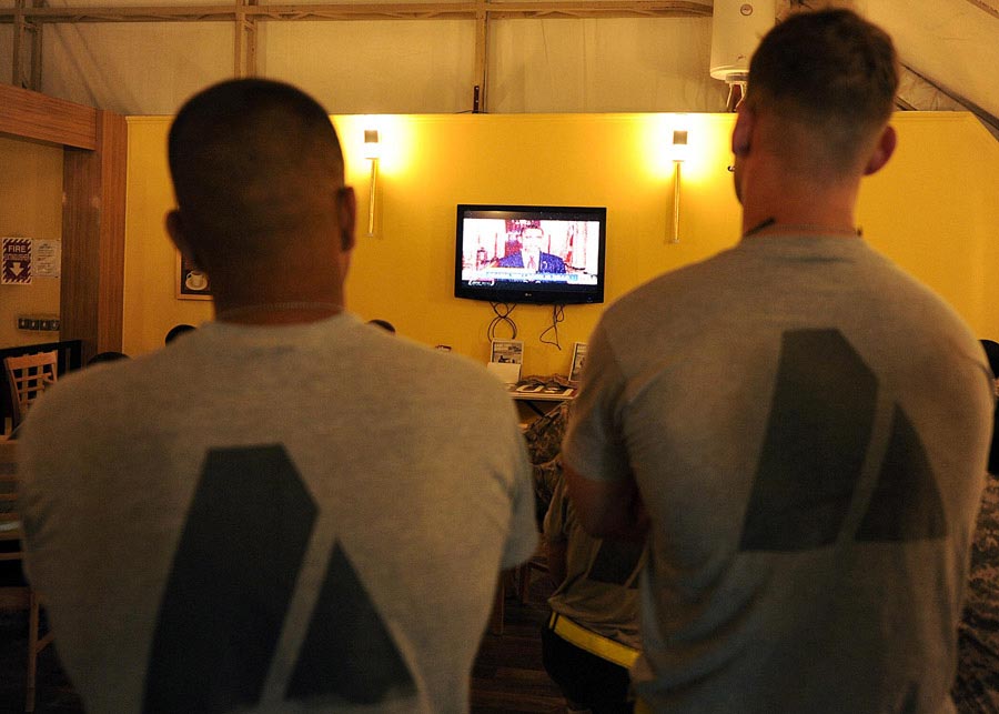 United States service members watch television as President Barack Obama talks about the details of the death of 9/11 mastermind Osama bin Laden