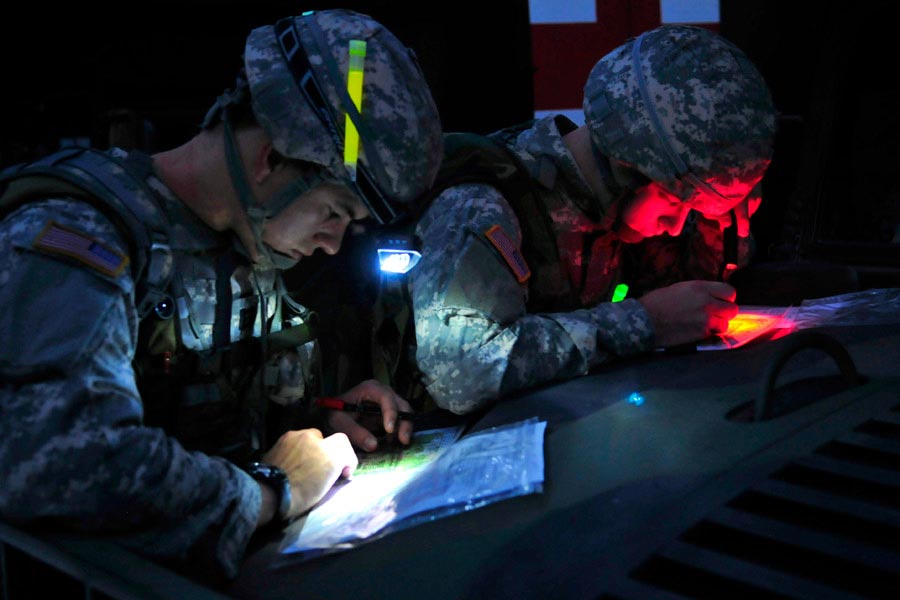 Captain Nick Franck, left, and Second Lieutenant Charles Smith plot their points on maps for the day-to-night land navigation course during the United States Army Europe Best Junior Officer Competition