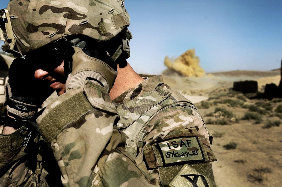 Private First Class Richard Mills secures his eyes and ears as Afghan National Army Soldiers conduct a controlled detonation