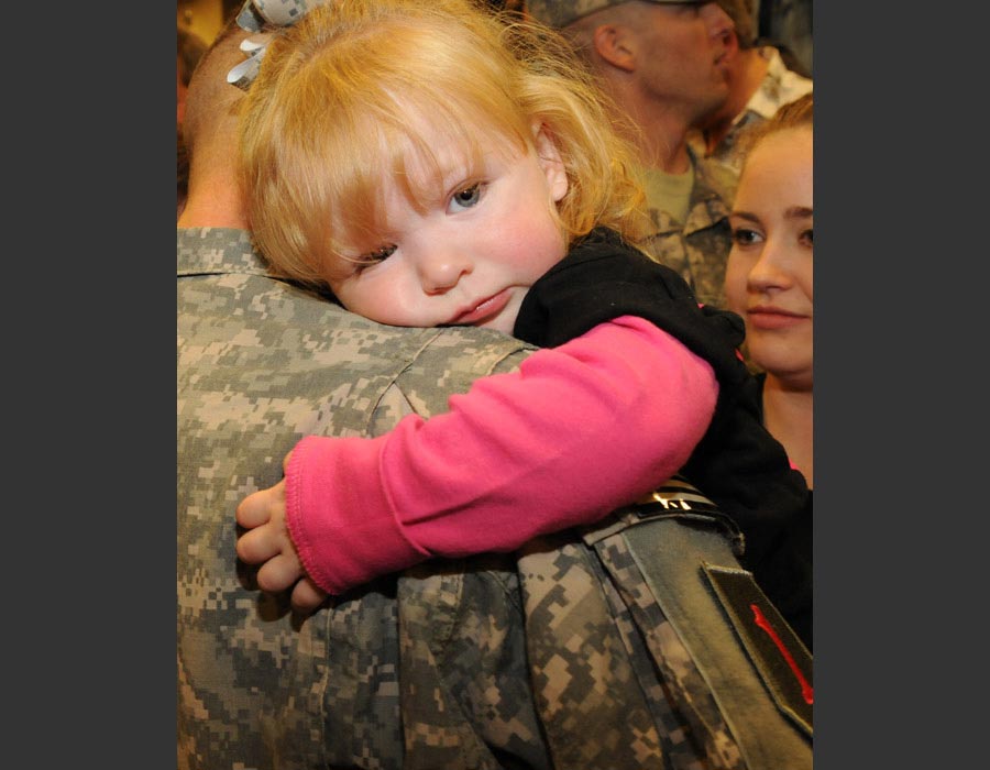 Abigail Castro, a 21-month-old, clings to her daddy, Specialist Kory Castro, following his return to Fort Riley, Kansas