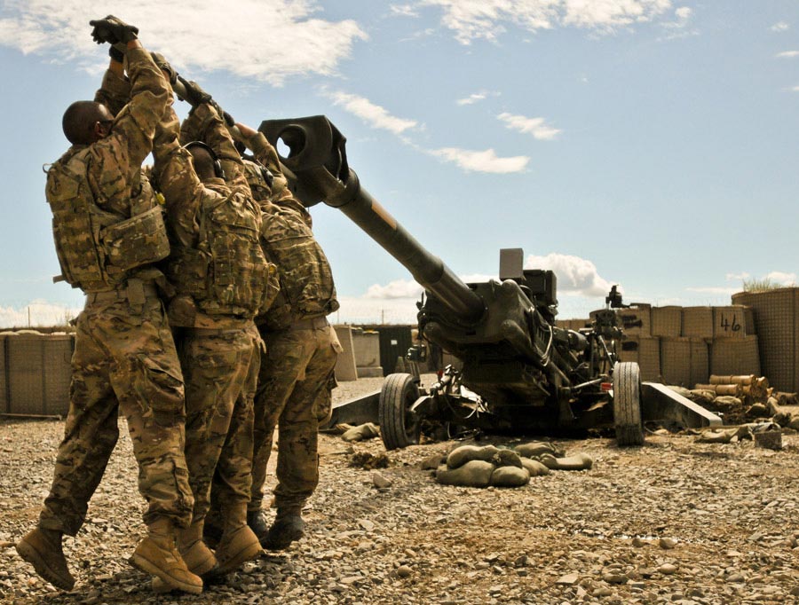 Soldiers work at dislodging their M-777 155mm howitzer from the three-foot deep hole it dug its spades into after firing several rocket-assisted projectiles