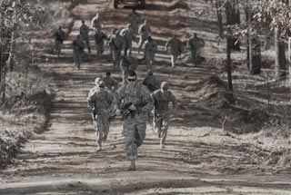 Specialist Christopher Pawson leads his artillery battery in a footrace through the forests of Fort Bragg, North Carolina, during a team-based competition