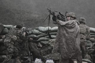 Soldier returns fire with a M249 light machine gun during combat operations in the valley of Barawala Kalet, Kunar province, Afghanistan