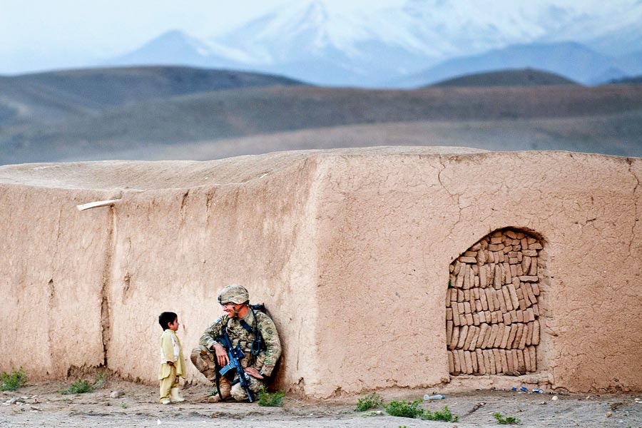 Sergeant Joshua Smith, with 82nd Airborne Division, chats with an Afghan boy