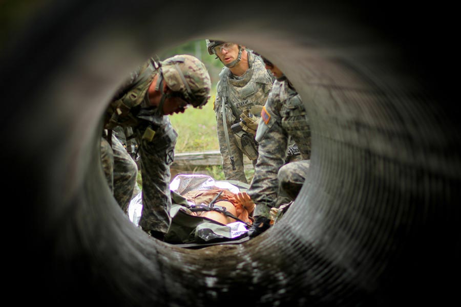 Corporal Eric Smith leads team of medics, assigned to 89th Cavalry Regiment, transport 'casualty' through culvert during best medic competition