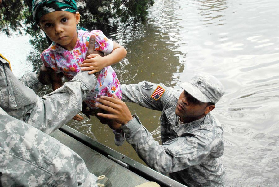 Sergeant Lee Savoy, with Louisiana National Guard, evacuates a child, from flood waters caused by Hurricane Isaac