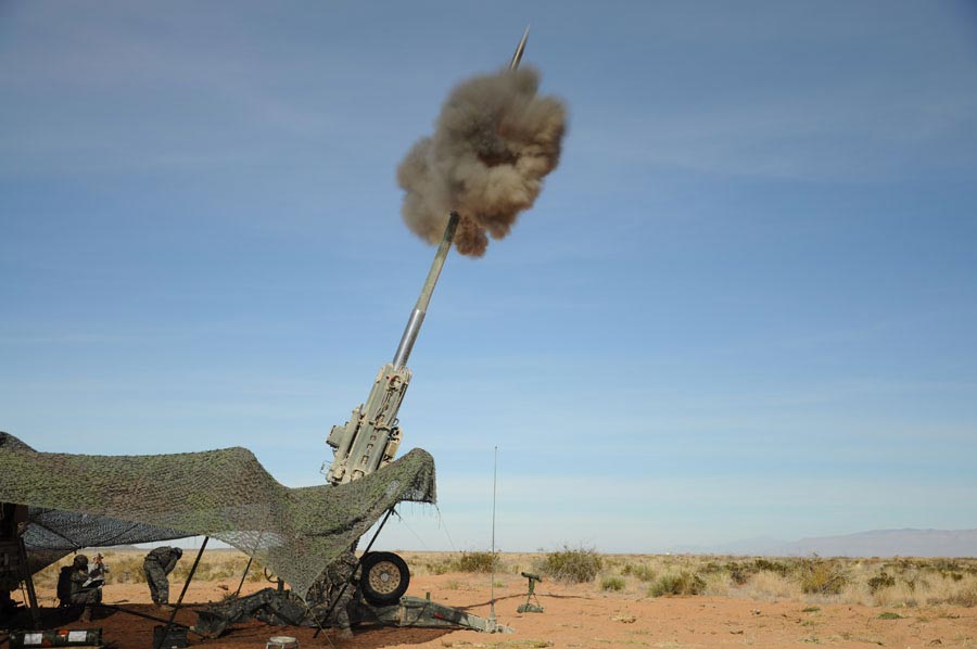 M982 Excalibur 155mm round leaves barrel of an M777 Howitzer during live-fire shoot