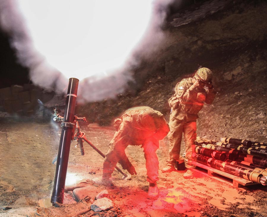 Specialist Jerel Martinez (near right) and Private First Class Andrew Bemis, indirect fire infantrymen assigned to 101st Airborne Division (Air Assault), fire 120mm mortar during night-fire