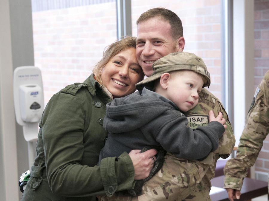 Valerie Kagan and her son Sean, hold tightly to their returning 2nd Infantry Division Soldier, Sergeant First Class Jeremy Kagan, after welcome-home ceremony