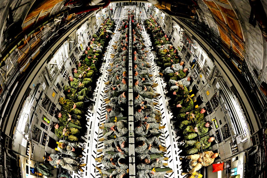 Soldiers from 82nd Airborne Division, and Canadian soldiers with 3rd Battalion, fill cargo area of U.S. Air Force Globemaster III aircraft