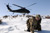 Sergeant First Class Shawn Joyce, of Lynn, Mass., with Task Force Poseidon, shields his face from blowing snow caused by a UH-60 Black Hawk landing nearby