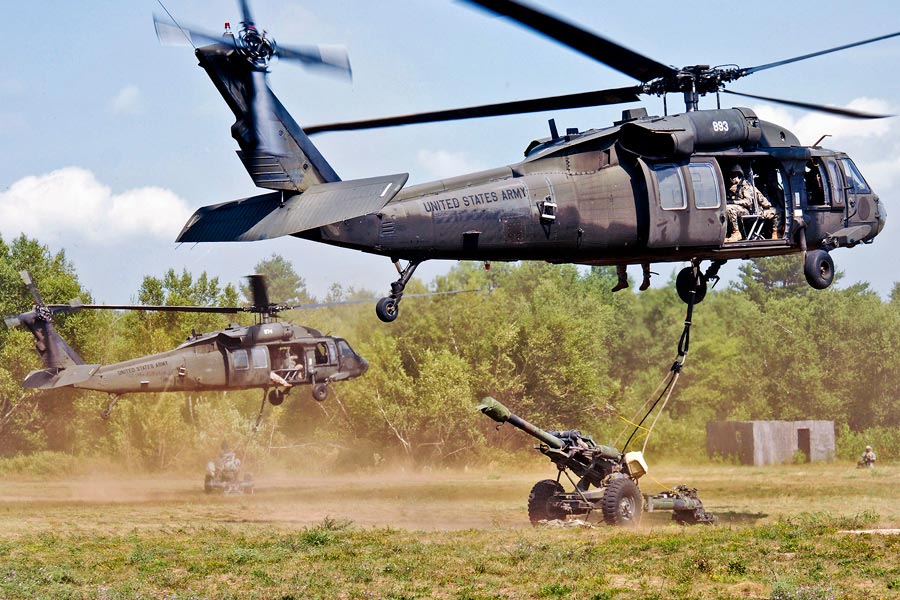 UH-60 Black Hawk helicopters airlift 105-mm howitzers to predetermined area on Fort Drum, N.Y.