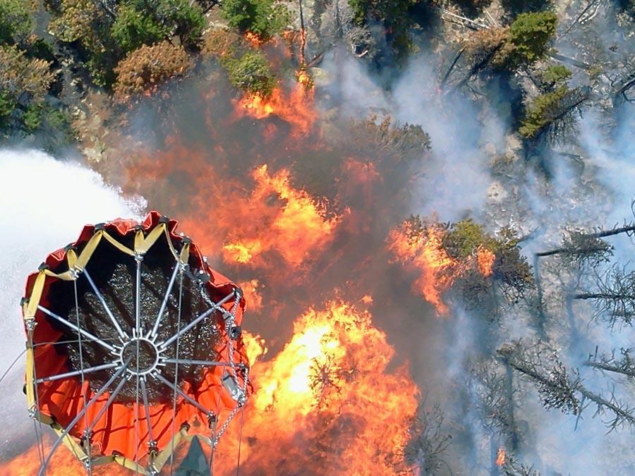Nebraska National Guard crewmembers, dump water from a 'Bambi Bucket' onto flames of the High Park fire