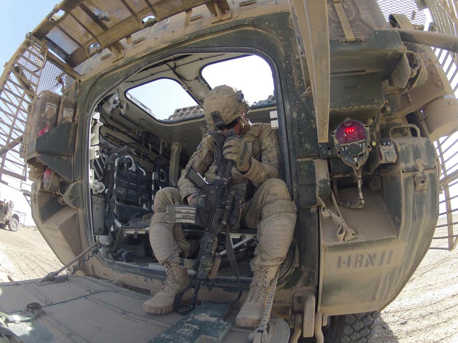 Specialist Tyler Winowiecki, an infantryman with 2nd Infantry Division, cleans dust off his M-4 carbine