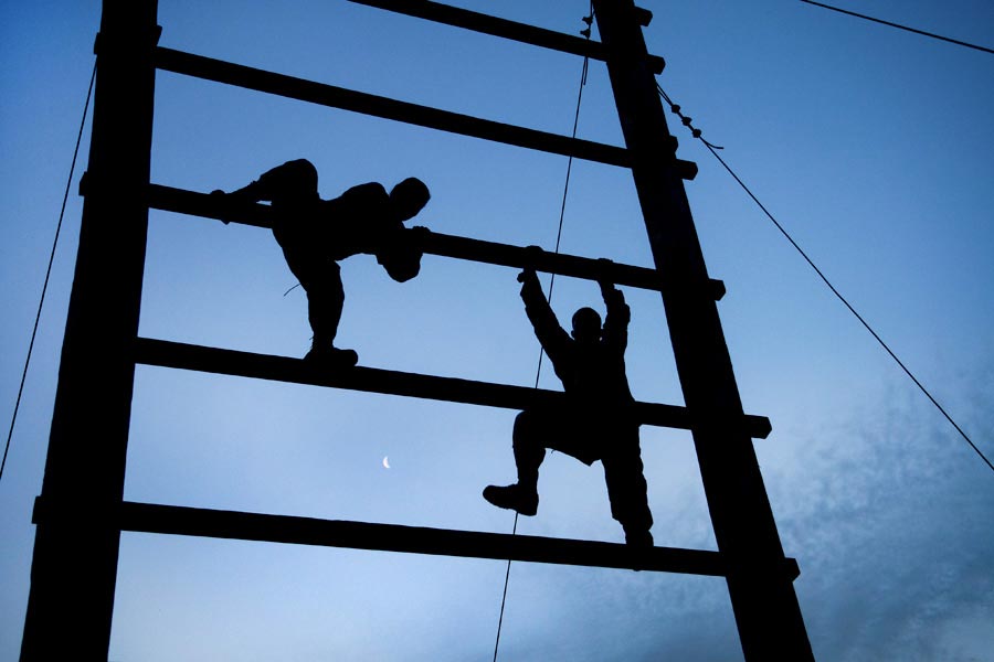 Soldiers from United States Army Reserve Command headquarters climb an obstacle