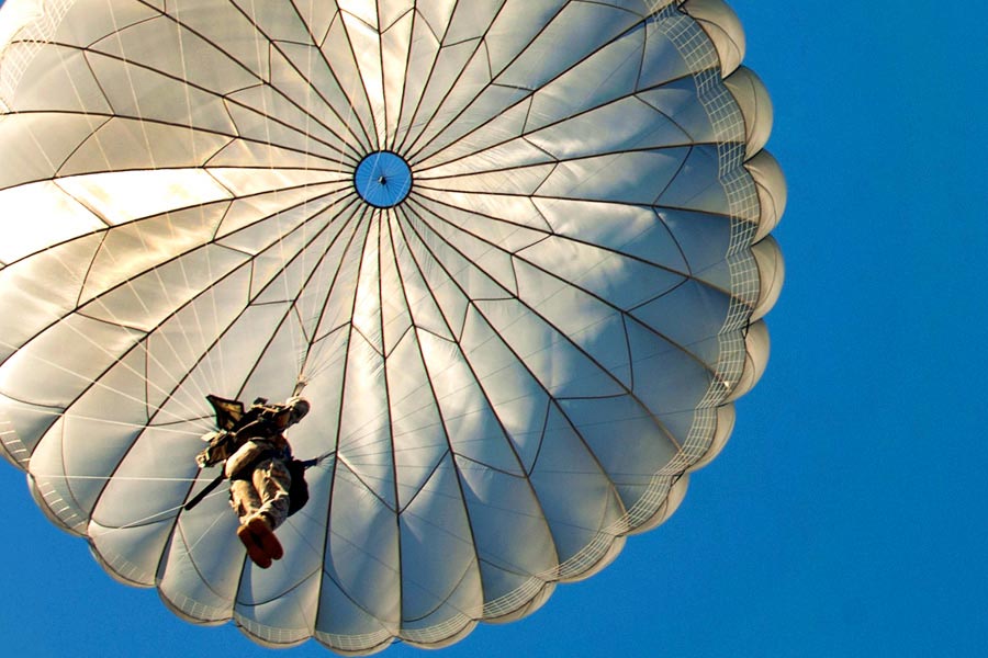 Paratroopers descend onto Fort Bragg’s Sicily Drop Zone after exiting Air Force C-130 aircraft over Fort Bragg, N.C.