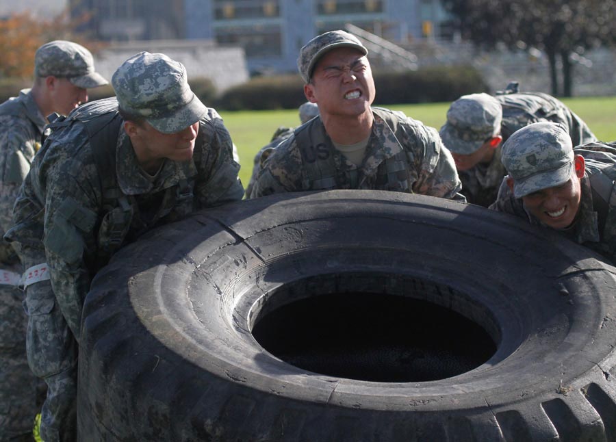 Soldiers trying to lift over-sized truck tire