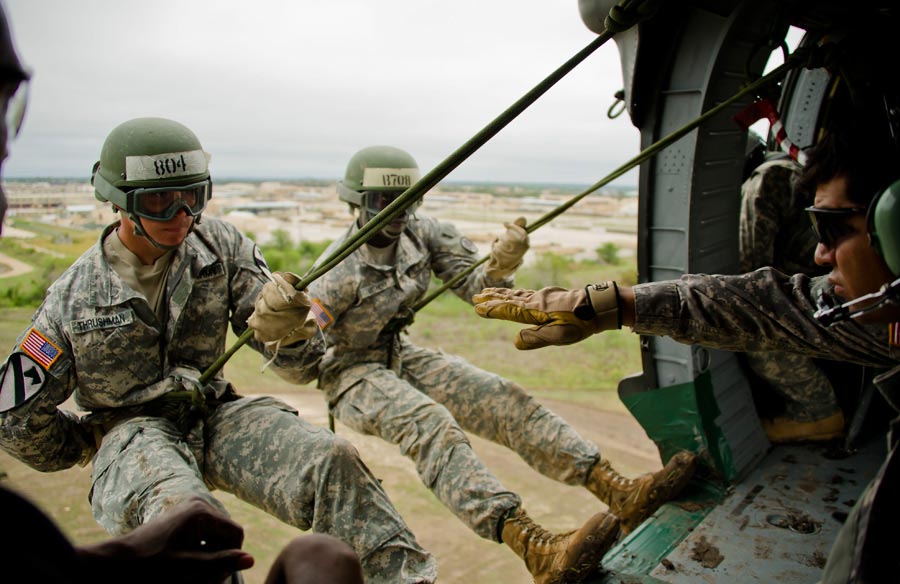 Sergeant Jon Garcia (right), gives student sign to rappel out of UH-60 Black Hawk Helicopter