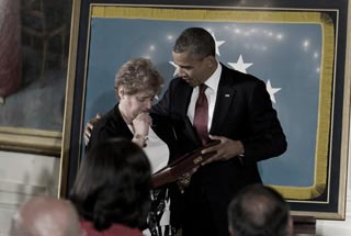 Rose Mary Brown, widow of Specialist Leslie H. Sabo Jr., accepts Sabo's Medal of Honor from President Obama