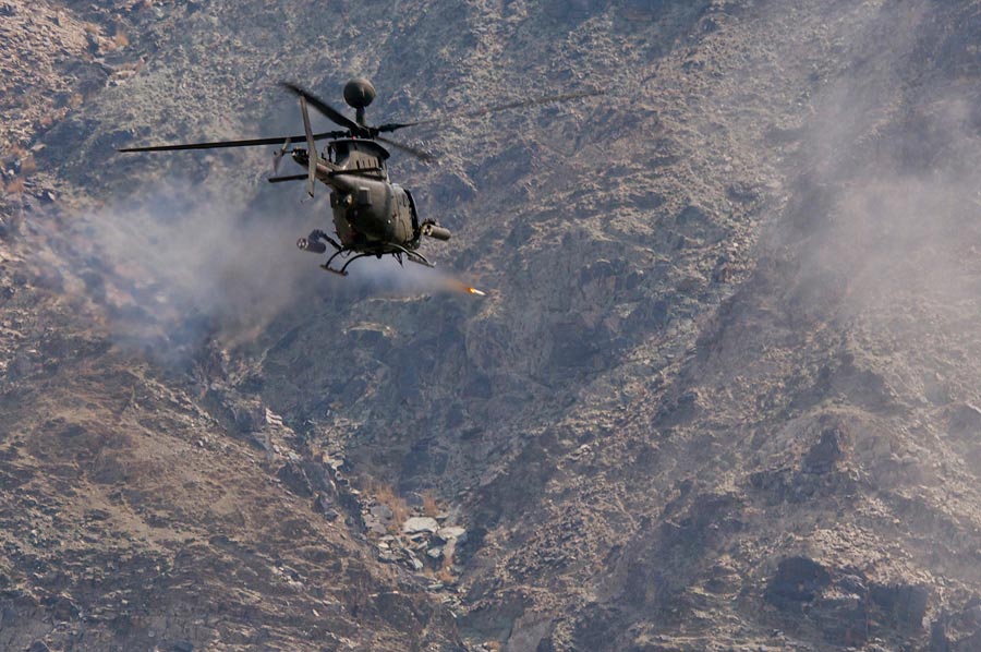 OH-58D Kiowa Warrior from 82nd Combat Aviation Brigade, fires 2.75-inch rocket at mountainside